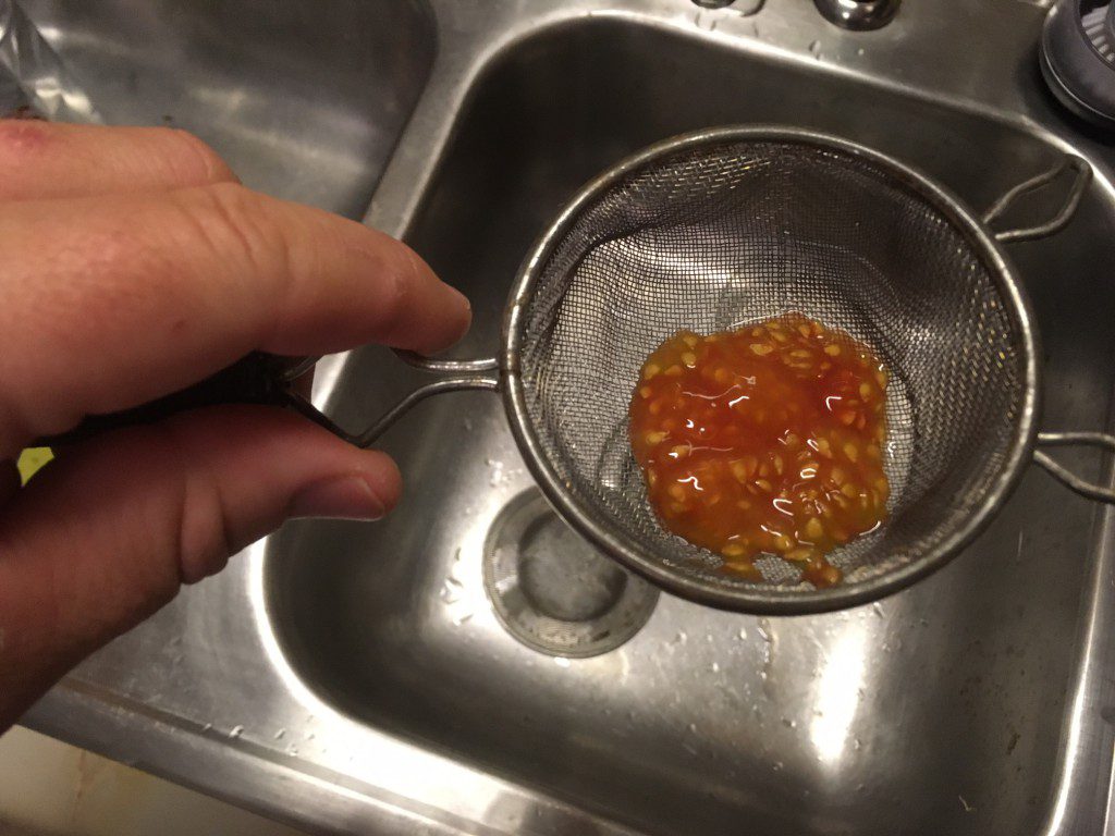 Tomatoes need a fermentation process to separate the seed from the mucous.  Start by scooping out a bunch of seeds into a glass jar.