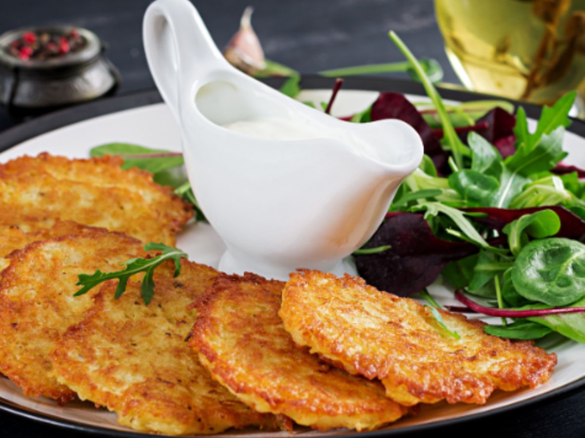 Potato pancakes arranged on a plate with mixed green salad