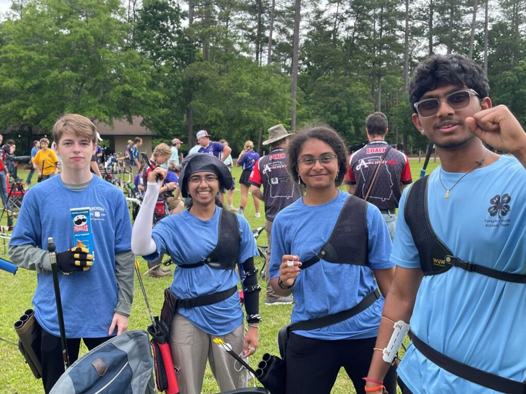 4 high school archers pose for a group photo