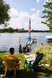 People enjoying the lake near American flag. Photo by Jamie Cooper.