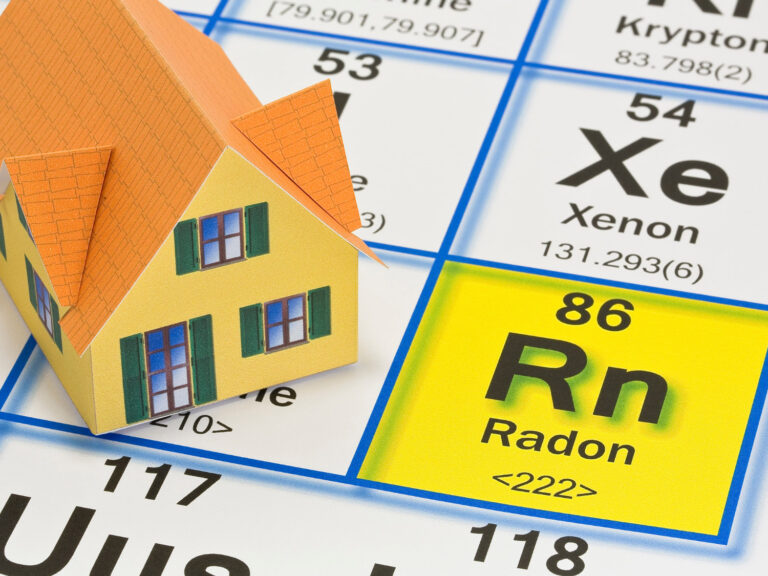 Yellow home sitting on a periodic table with Radon highlighted.