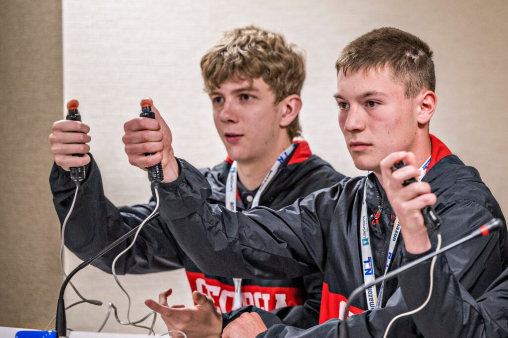 Two middle school students holding buzzers to participate in a speed response contest