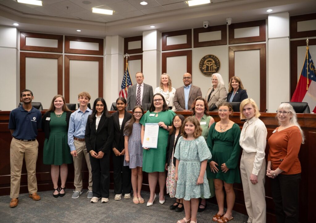 A large group of youth and adults posing for a photo with local government leaders