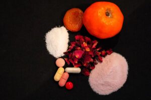an orange, a dried apricot, some pills and two powders