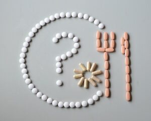 supplement pills laid in an outline of a dinner plate and serving ware
