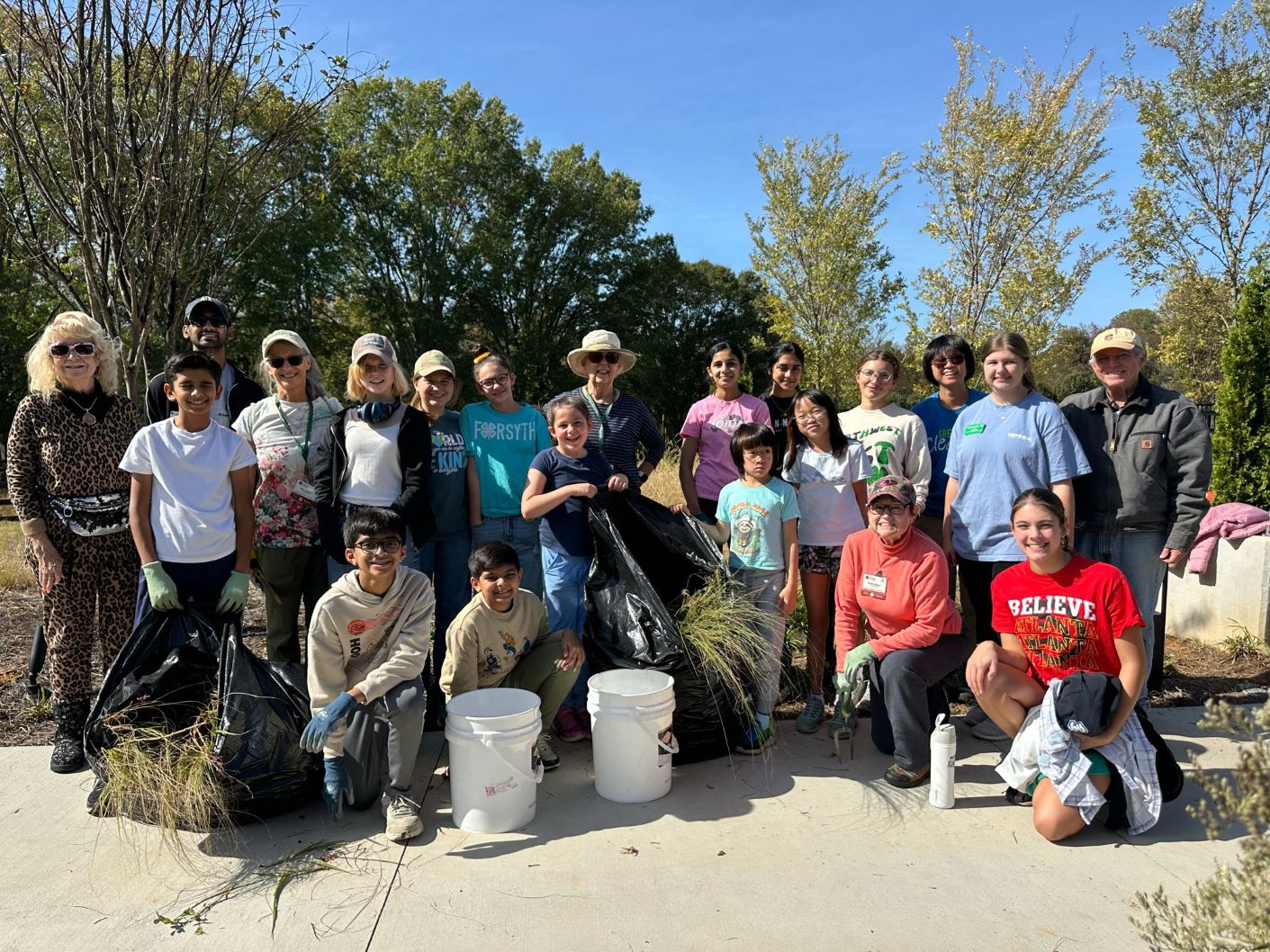 A mixed group of adults and students posing outdoor