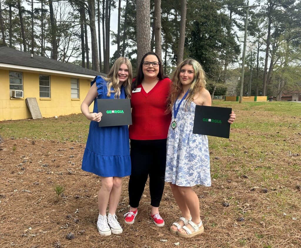 Two students pose with their 4-H Agent at Rock Eagle 4-H Center. 
