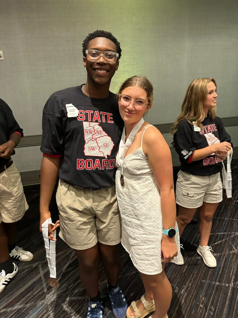 4-H student posing with another student, wearing her 3rd place medal