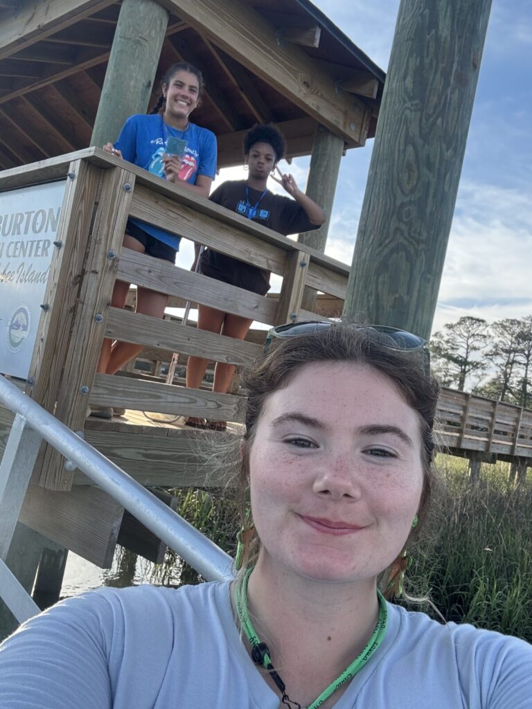 A selfie taken by a teen leader of her and two students on a boardwalk 