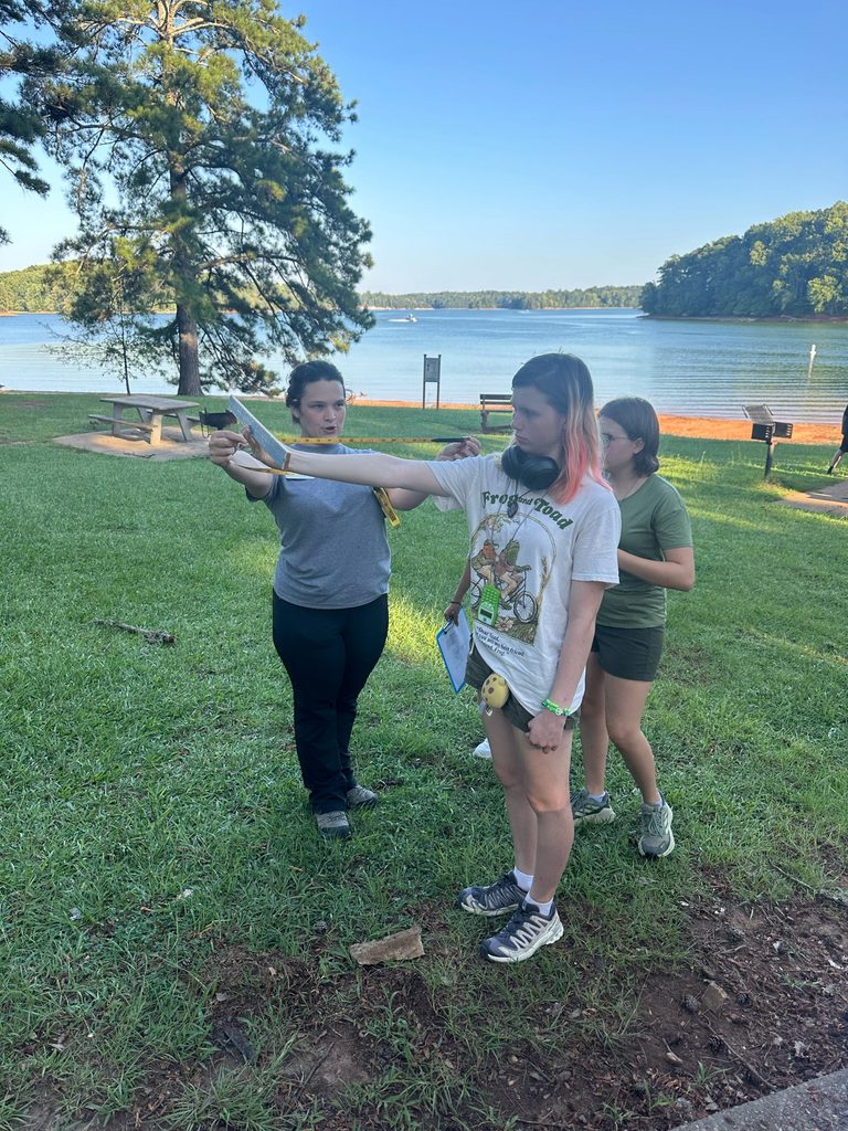 A forestry student practicing with the assistance of her teacher 