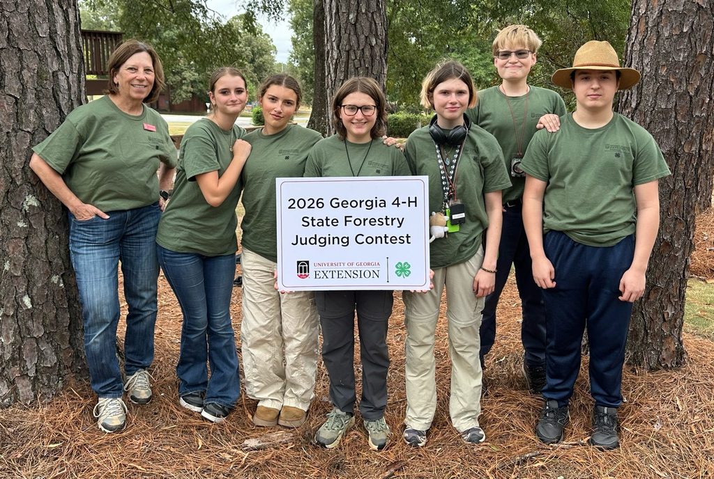 A group of students posing with a poster at the state forestry competition. 