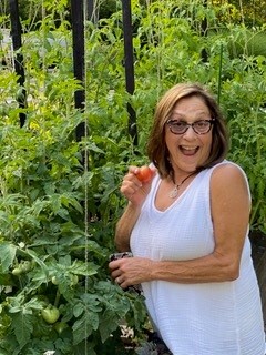 The author standing next to a tomato plant