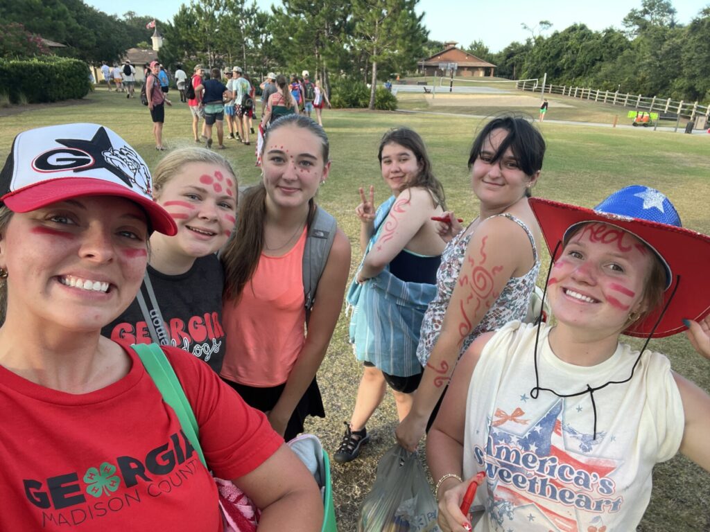 Six campers standing on the grass with smiles on their faces.