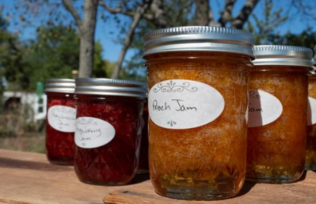 Cans of jams in jellies sitting on a table outside